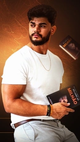 Tondimás Torres segurando um livro contra fundo laranja com luvas de boxe visíveis